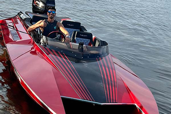 man sitting in a red sports boat